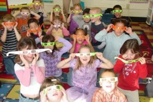 Kids showing off solar eclipse glasses.