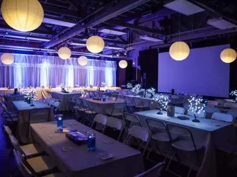 decorated event space with long tables and hanging globe lanterns