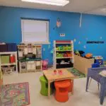 Early childhood classroom with sensory bin and pretend play areas