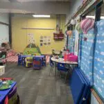 Early childhood classroom with decorative miniature hot air balloons, learning stations, and a reading tent