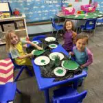 Children painting with green paint